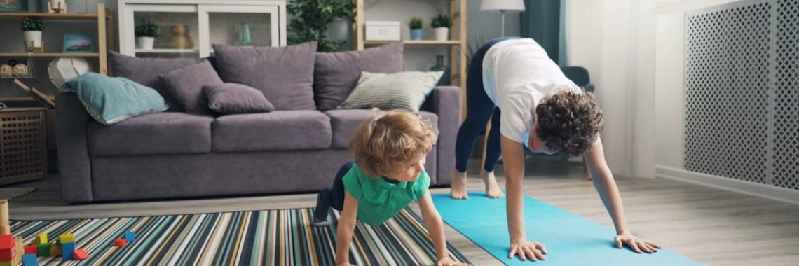 a woman and a child doing yoga in a living room